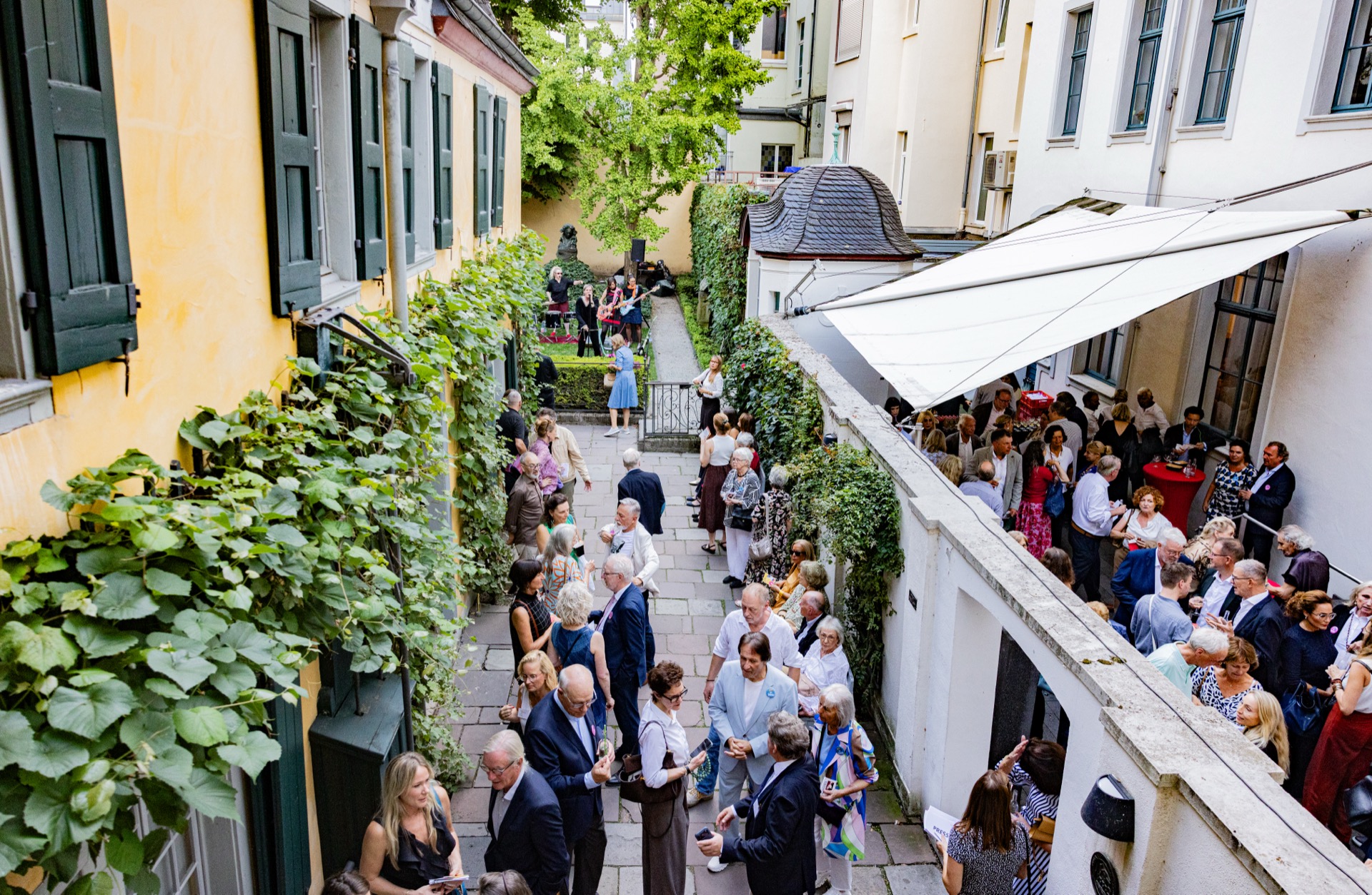 Gäste im Innenhof des Beethoven-Hauses Bonn bei der Ausstellungseröffnung „Beethoven by Warhol“